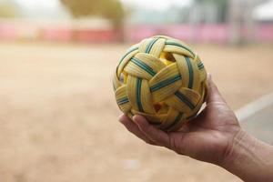 detailopname Mens houden sepak takraw bal buitenshuis. concept, Aziatisch traditioneel sport. een bal gemaakt van rotan of synthetisch plastic. sport met uitrusting dat kan Speel voor buitenshuis of binnen. competitief spel. foto