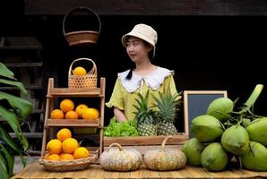 Azië vrouw verkoop een natuurlijk verscheidenheid van fruit Bij de boerderij blijven foto