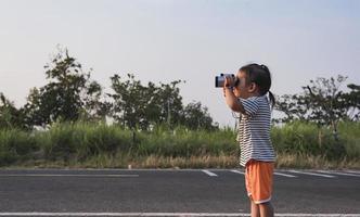 schattig meisje op zoek door verrekijker, concept van hiking, camping en avontuur. foto