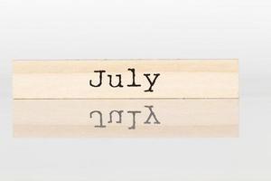 houten kubus met de opschrift juli Aan een wit achtergrond foto