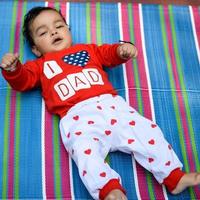 schattig weinig Indisch zuigeling zittend genieten van buitenshuis schieten Bij maatschappij park in Delhi, schattig baby jongen zittend Aan kleurrijk mat met gras in de omgeving van, baby jongen buitenshuis schieten foto