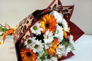 foto van een boeket van oranje en wit bloemen Aan een wit achtergrond