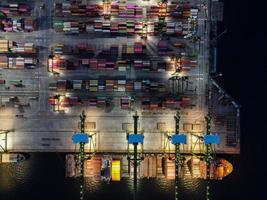 Jakarta, Indonesië 2021 - luchtfoto van het laden en lossen van containerschepen in de diepzeehaven, logistieke import en export van vrachtvervoer per containerschip op open zee 's nachts foto