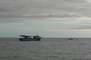 de vissers boot is Aan de zee in de avond foto