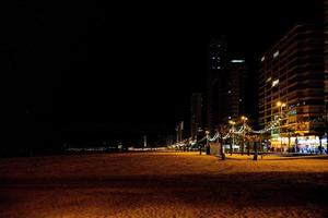 kust strand landschap met promenade Bij nacht in benidorm, Spanje foto