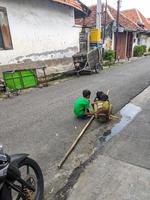 soera, Indonesië - april, 2023 - een sommige Aziatisch jongens verzameld Holding bamboe foto
