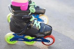 vrouw Kaukasisch rol schaatser poten in kleurrijk vleet schoenen voor in lijn en slalom het schaatsen staand Aan asfalt foto