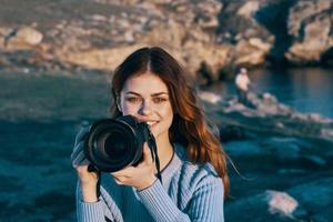 vrouw met camera in natuur nemen afbeeldingen van landschap professioneel foto