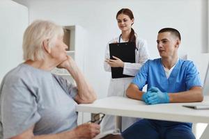 ouderen vrouw in de dokter kantoor en verpleegster onderhoud communicatie foto