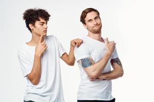 twee mannen in wit t-shirts zijn staand kant door kant geïsoleerd achtergrond foto