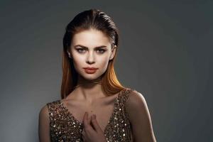 vrouw in goud jurk en oorbellen sieraden aantrekkingskracht model- foto