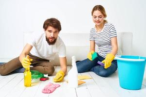 Mens en vrouw het wassen vloeren schoonmaak benodigdheden interieur samenspel foto