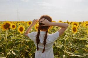 vrouw met twee vlechten in een veld- van zonnebloemen platteland foto