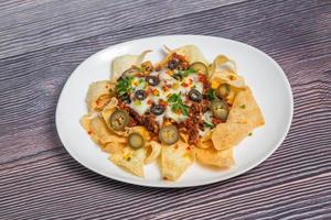 Mexicaans beroemd voedsel pittig grond rundvlees nacho's. verwarmde knapperig tortilla chips met gesmolten kaas en jalapeno geserveerd een tussendoortje voedsel. foto