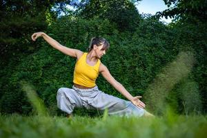 jong vrouw beoefenen tai chi Chuan in natuur. Chinese beheer vaardigheid qi's energie. foto