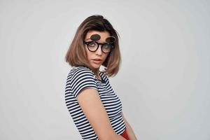 vrouw vervelend mode bril gestreept t-shirt licht achtergrond aantrekkingskracht foto