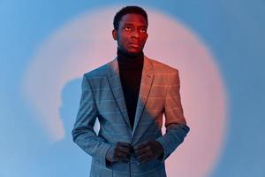 Mens vervelend jasje Afrikaanse uiterlijk bijgesneden visie neon achtergrond mode foto