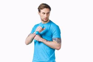 sportief Mens in blauw t-shirt van halters in handen geschiktheid bijgesneden visie foto