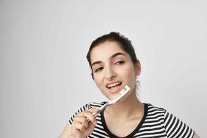 vrolijk vrouw borstel uw tanden met een tandenborstel licht achtergrond foto