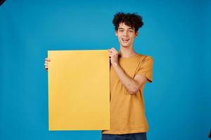 vrolijk Mens met geel poster mockup blauw achtergrond studio foto