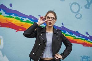 Dames in de buurt de graffiti Aan de muur in de het formulier van een regenboog in de straat foto