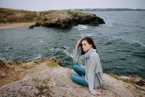 mooi vrouw strand toerisme bewolkt weer steen kust ontspanning concept foto