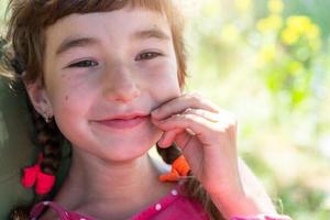 zomer portret van een gelukkig baby meisje met een parmantig en ondeugend glimlach detailopname. foto