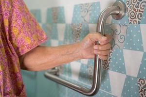 Aziatisch ouderen vrouw geduldig gebruik toilet badkamer omgaan met veiligheid in verpleging ziekenhuis, gezond sterk medisch concept. foto