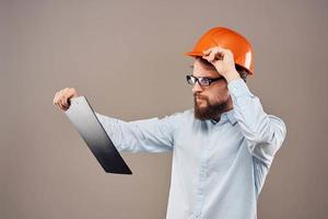 Mens in oranje moeilijk hoed professioneel veiligheid handleiding documenten werk foto