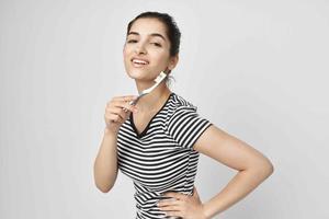 brunette borstel uw tanden met een tandenborstel geïsoleerd achtergrond foto