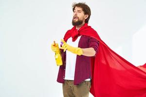 Mens in rood regenjas vervelend rubber handschoenen professioneel helpen in de omgeving van de huis schoonmaak foto