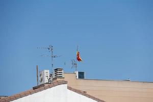 achtergrond met Spaans betegeld daken van huizen tegen een wolkenloos blauw lucht foto