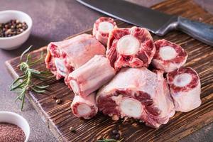 stukken van rauw ossenstaart en specerijen voor Koken Aan een houten bord Aan de tafel foto