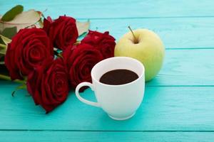 kop van koffie met croissants en koekjes en rood rozen Aan blauw houten achtergrond. kopiëren ruimte. bespotten omhoog. top visie. Valentijn moeder dag. foto