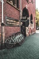 amsterdam, nederland 2015- fietsenstalling naast een bakstenen gebouw foto