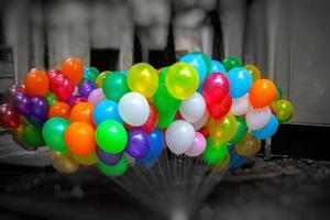 een bundel van kleurrijk met gas gevuld ballonnen Aan donker achtergrond. foto