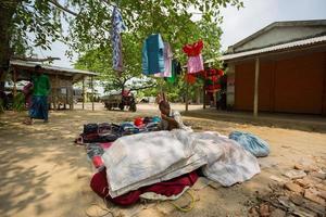 Bangladesh mei 19, 2019 een landelijk dorp zakenman verkoop kleding en producten naar hangen omhoog Aan de boom kofferbak, meerpur, bangladesh. foto