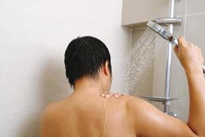 een Mens is gebruik makend van douche room voor droog huid geeft terug huid naar worden zacht, gehydrateerd en gevoed foto