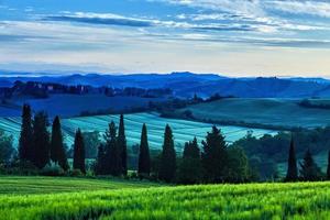 zonsopgang boven bochtige heuvels in Toscane foto