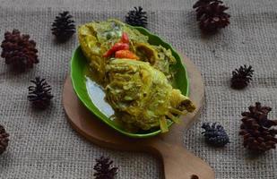 gulai kepala kakap of snapper vis hoofd, gekookt in kerrie kruiden, het smaakt pittig, verzuren en hartig. traditioneel padang keuken, west sumatra, Indonesië. foto