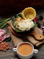 selectief focus van asinan betawi. de groente asinan van de betawi mensen van Jakarta is bewaard gebleven Chinese kool, kool, Boon spruiten, tofu, en sla geserveerd met pinda saus en kroepoek foto