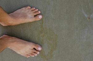 voeten staand Aan zand strand concept achtergrond foto