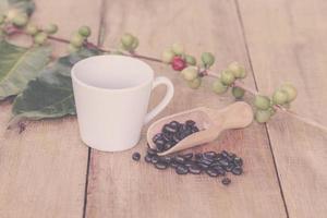 vers koffie bonen Aan hout en koffie kop foto