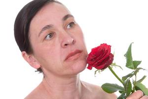 detailopname gezicht van een volwassen vrouw met een roos. tekens van huid veroudering na 40 foto