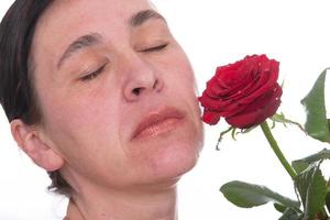 detailopname gezicht van een volwassen vrouw met een roos. tekens van huid veroudering na 40 foto