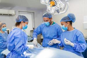 schot van een team van chirurgen het uitvoeren van een chirurgie in een in werking theater foto
