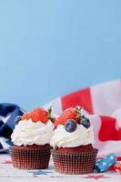 zoet cupcakes met bosbessen en aardbei , Verenigde Staten van Amerika vlag Aan blauw achtergrond foto