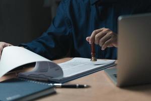 ondertekening goedkeuring Vermelding documenten postzegel bevestiging bezetting handtekening. zakenman hand- stempelen financiën papier werk concept. foto