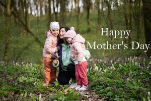 gelukkig moeder dag. wij liefde jij, mama. moeder met een boeket van bloemen en twee dochters in voorjaar bloeiend Woud. foto