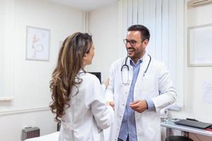 concept van samenwerking in geneesmiddel. foto van twee dokters handdruk in ziekenhuis